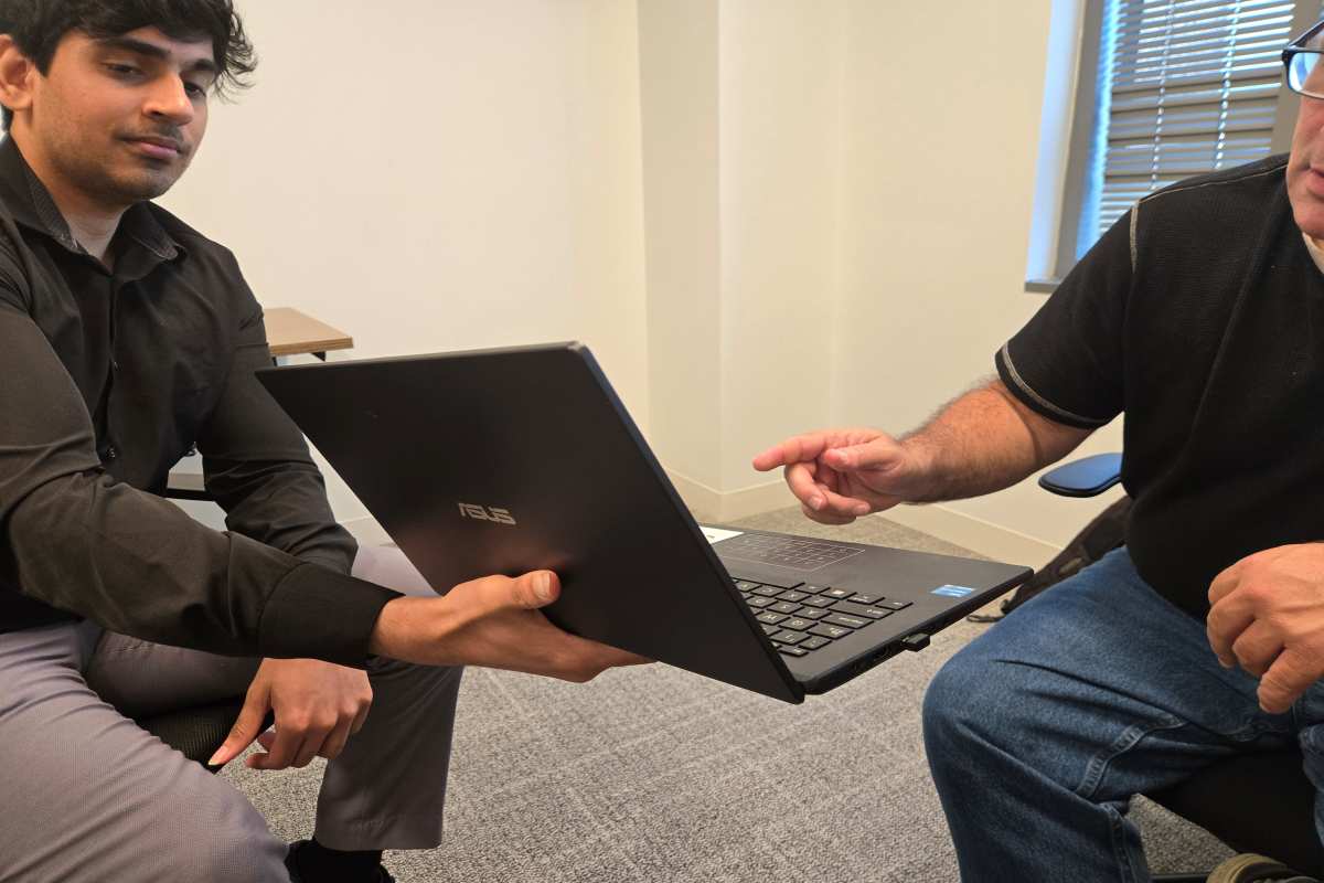 Interim CFO Seeing Financial Stats in Laptop with His Assistant