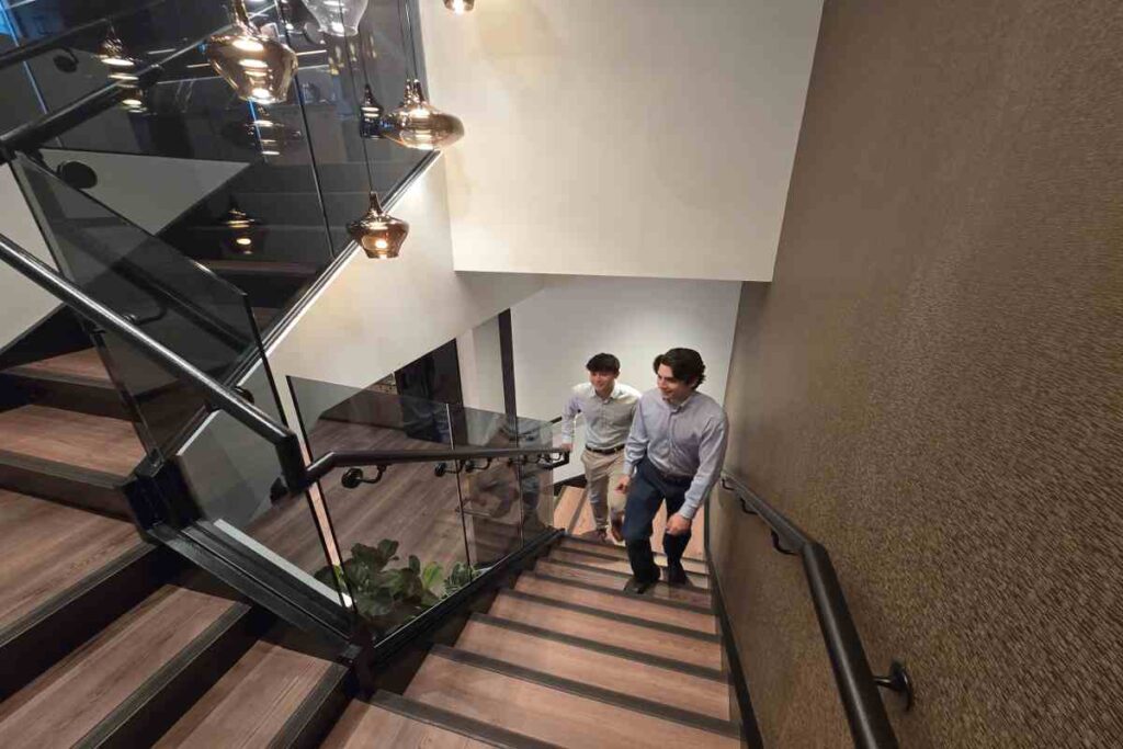 M&A Advisors Coming Upside From Stairs While Talking