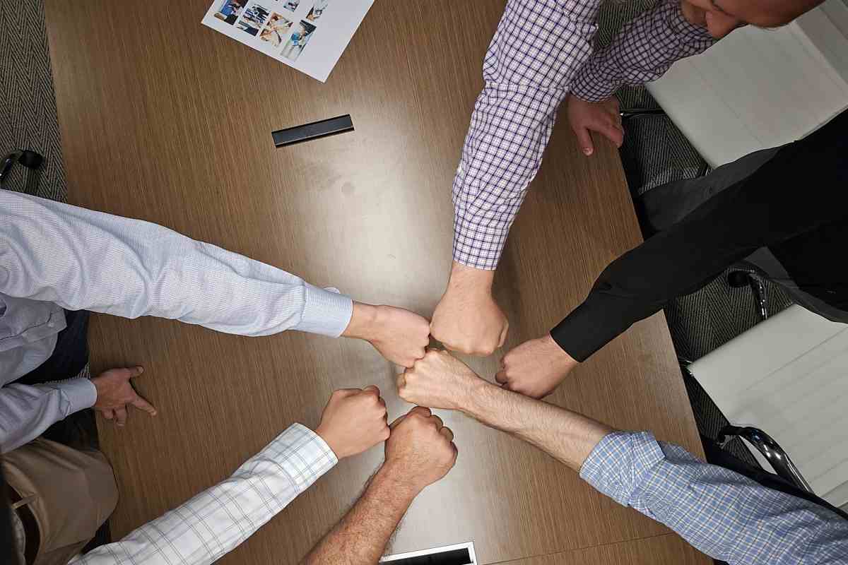 M&A Consultants Having Fist Bump For Maximizing Value