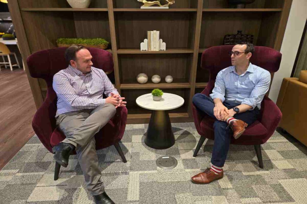 Two M&A Advisors Sitting on Chairs And Talking to Each Other
