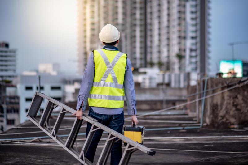 Employee About To Perform Maintenance On The Roof Of A Building