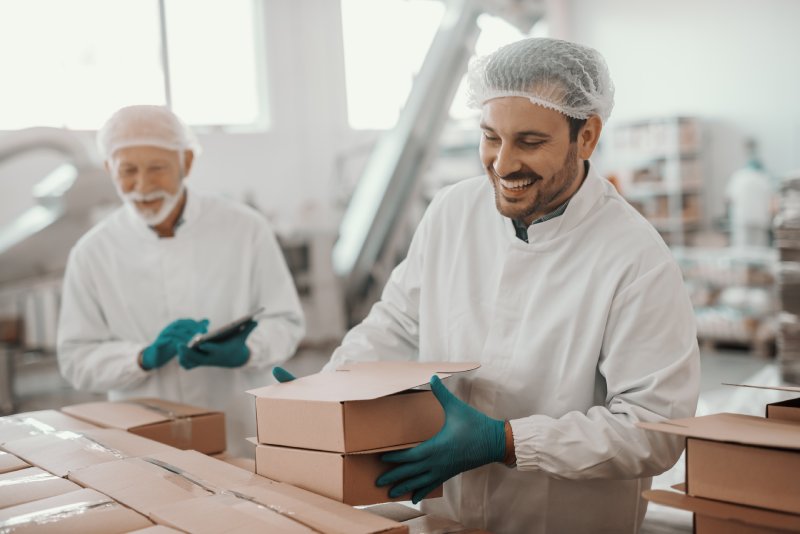 Two Men Boxing Up Food From Manufacturing Facility