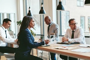 diverse group of businesspeople talking together around an office table