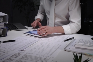 Businessman Analyzing Sell-Side Earning Report Using Tablet on His Desk
