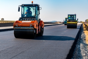 Paving Firm Worker Flattening the Asphalt Material with Road Rollers