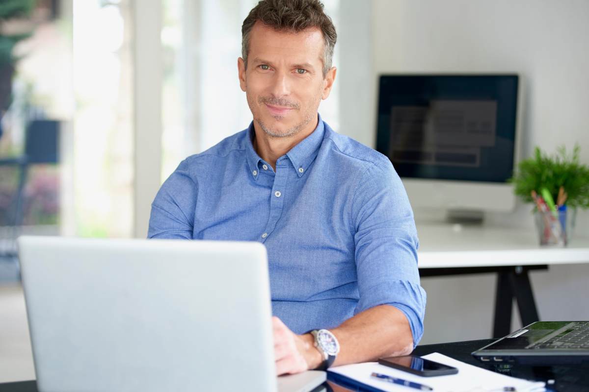 Professional M & A Advisor Working on Laptop in His Office