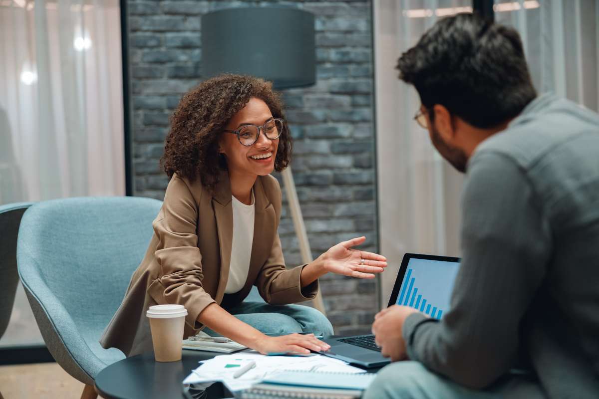 Smiling Female Consultant Advising Sell-Side Diligence Plan to Businessman