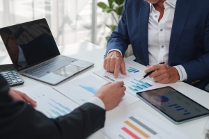 Business People Reviewing TTM EBITDA Report Charts in Office