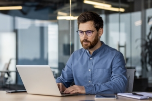 M&A Advisor Creating a Buyer List on His Laptop