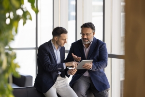 Senior Sell-Side Advisor Showing Selling Process to Business Owner on Tablet